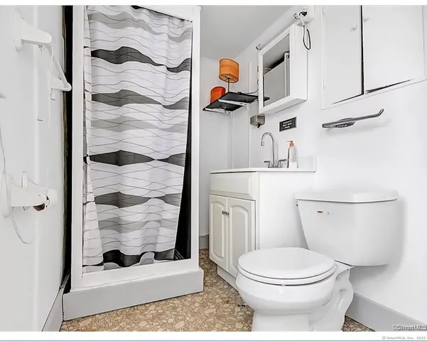 a bathroom with a toilet and a shower