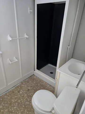 a bathroom with a toilet and a shower