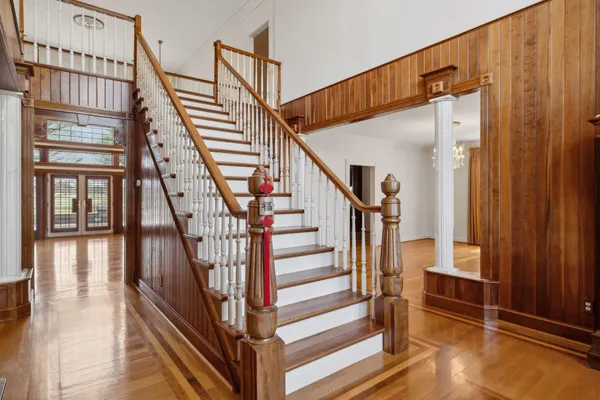 a view of an empty room with window and hardwood floor