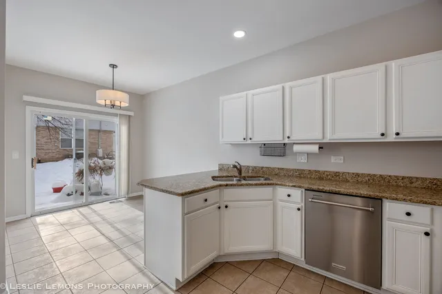 a kitchen with granite countertop white cabinets and white appliances