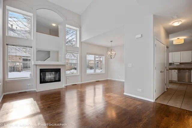 a view of a livingroom with wooden floor and a fireplace