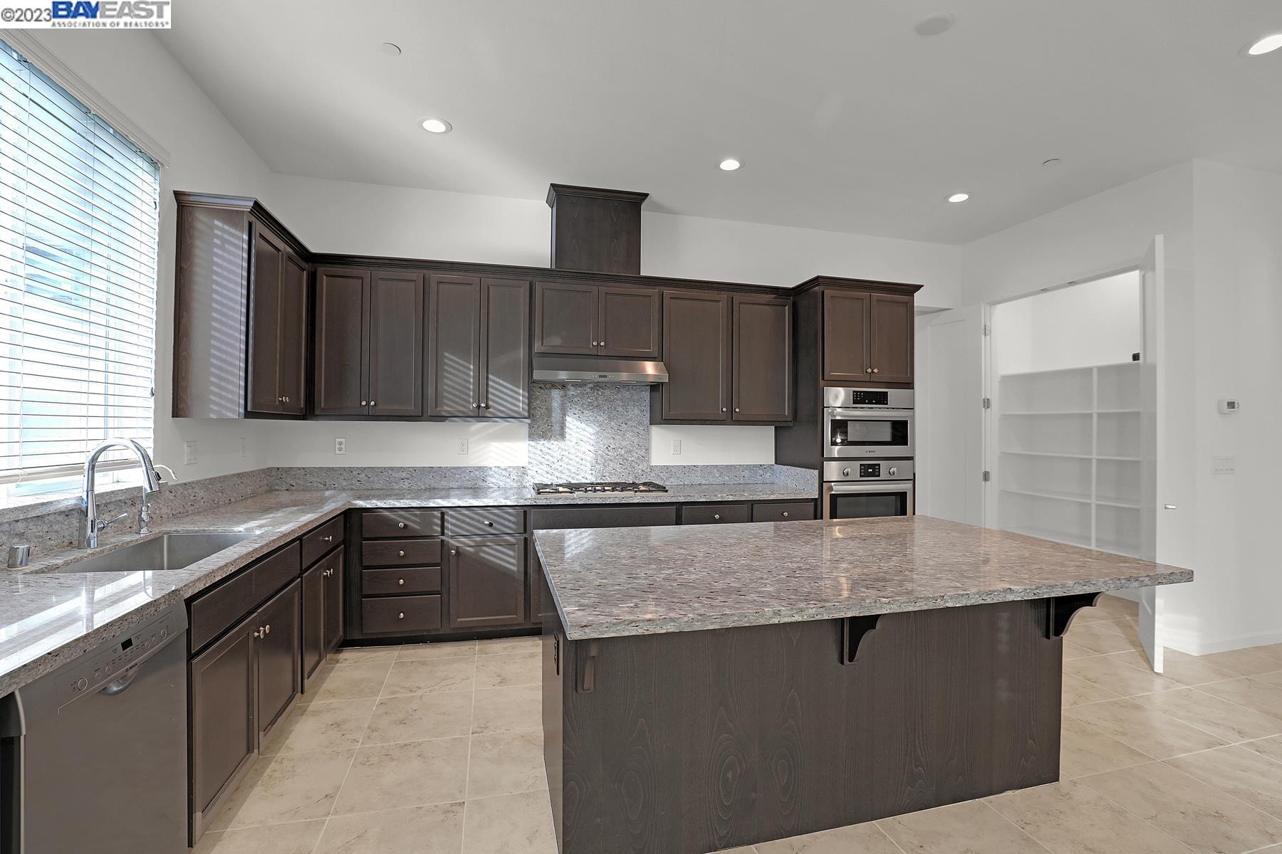 5772 Barley Road Dublin, CA 94568 - Photo 12 of 56 a kitchen with stainless steel appliances granite countertop a sink dishwasher a stove and a refrigerator with wooden floor