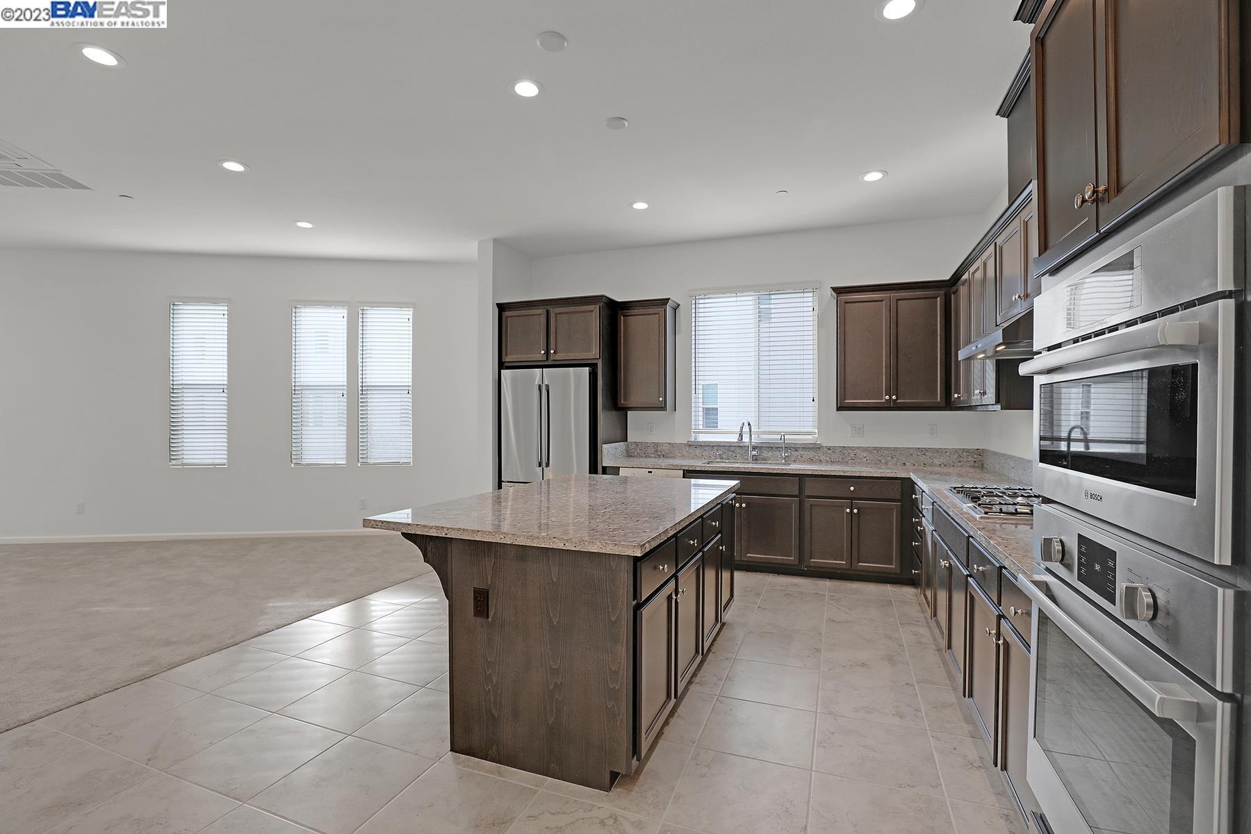 5772 Barley Road Dublin, CA 94568 - Photo 13 of 56 a kitchen with stainless steel appliances granite countertop a sink stove microwave and refrigerator