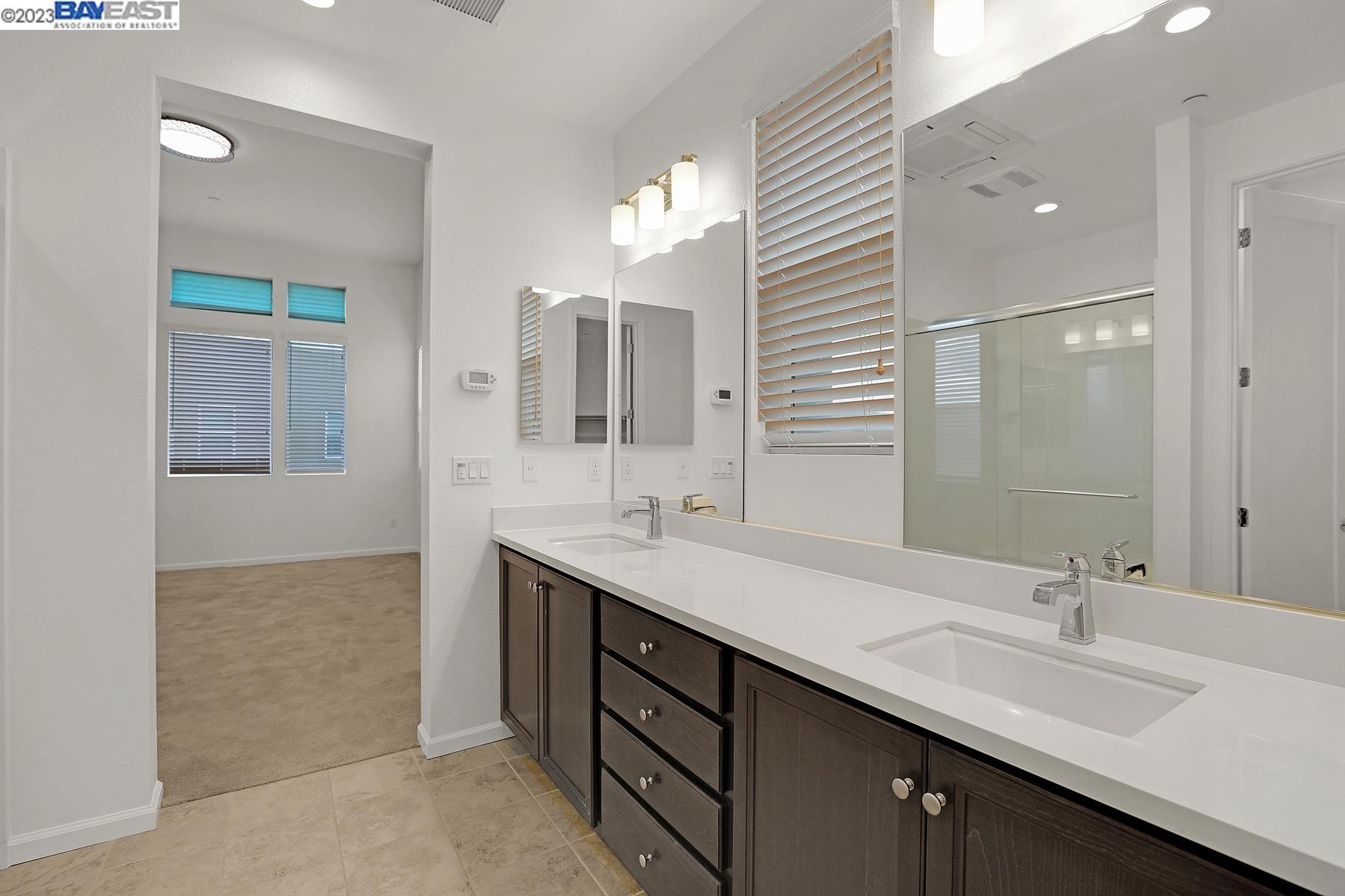5772 Barley Road Dublin, CA 94568 - Photo 29 of 56 a bathroom with a double vanity sink a mirror and a shower