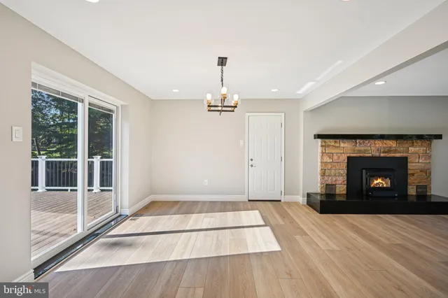 a view of an empty room with a fireplace and a window