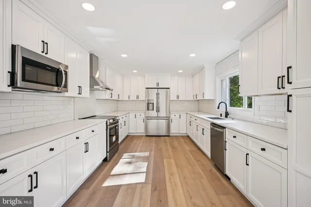a large kitchen with cabinets stainless steel appliances a sink a window and counter space