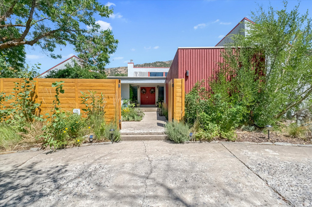 510 Spring Creek Road Providence, UT 84332 - Photo 1 of 97 Contemporary exterior featuring a red corrugated metal accent wall, a red front door, and a horizontal wood fence