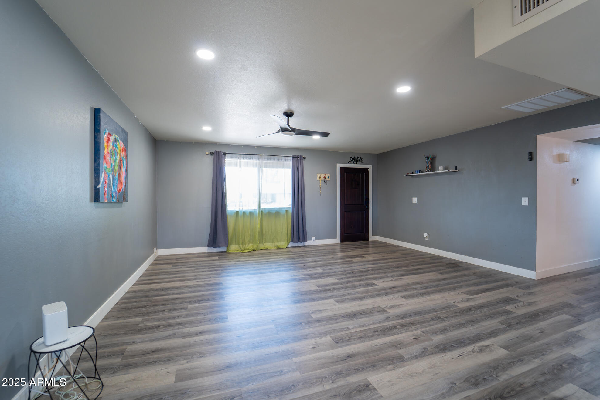3102 West Paradise Drive Phoenix, AZ 85029 - Photo 5 of 22 a view of an empty room with a window and wooden floor