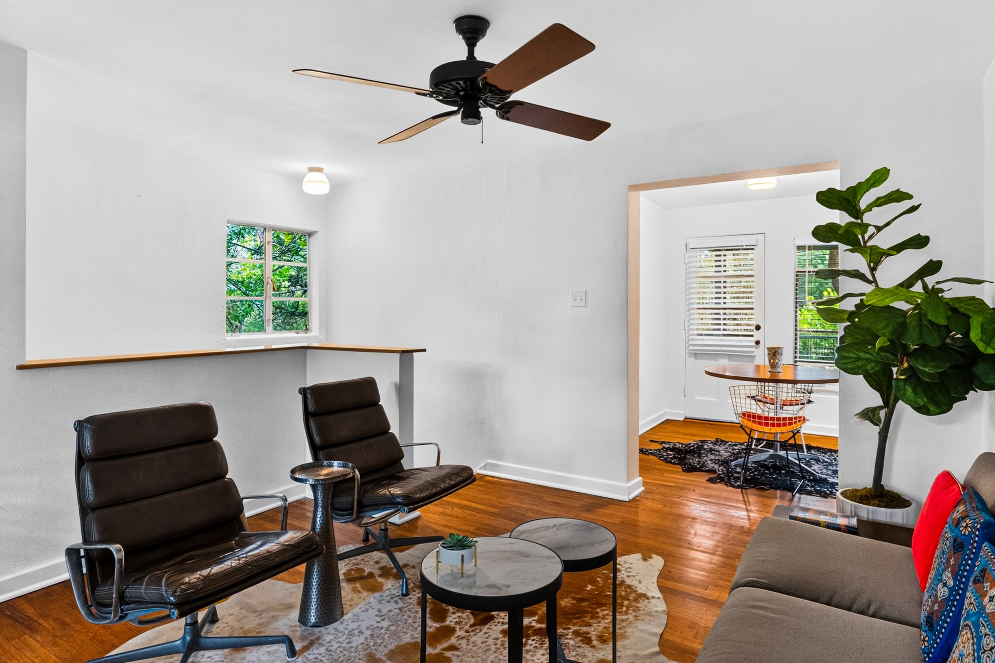 1302 Kirkwood Road, Unit B Austin, TX 78722 - Photo 4 of 21 Hardwood floors and a ceiling fan enhance this inviting sitting area, flowing into a casual dining space.