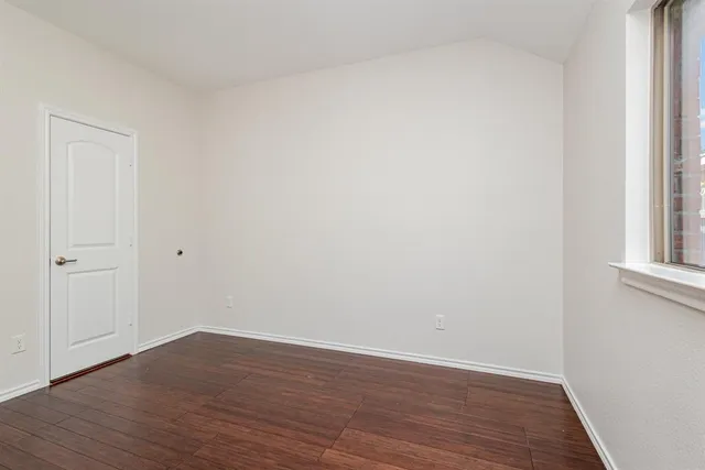 a view of an empty room with wooden floor