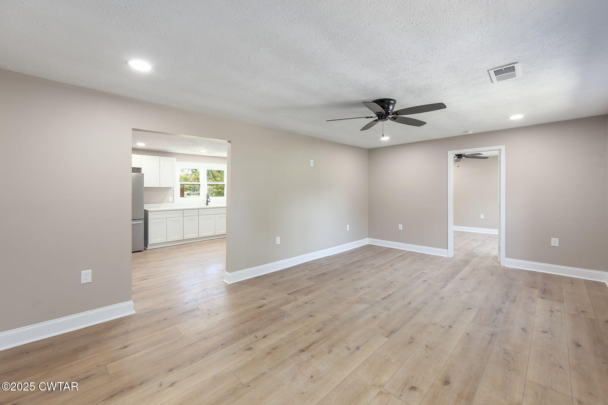 424 Rozelle Street Gibson, TN 38343 - Photo 3 of 20 an empty room with wooden floor and windows