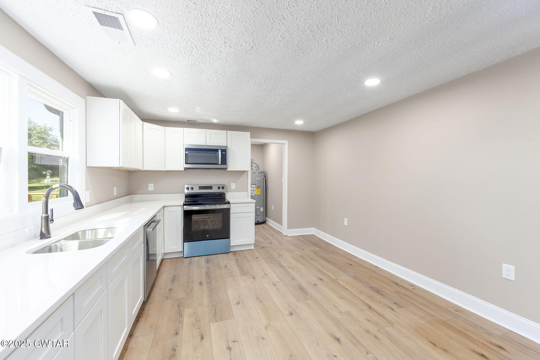 424 Rozelle Street Gibson, TN 38343 - Photo 8 of 20 a large kitchen with a white stove top oven and sink