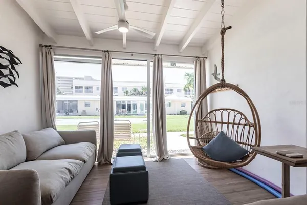 a living room with furniture a flat screen tv and a large window