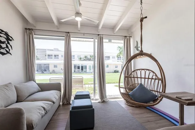 a living room with furniture a flat screen tv and a large window