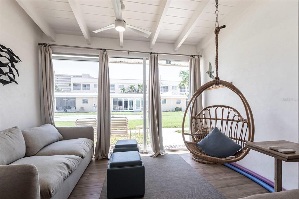 6006 Midnight Pass Road, Unit 53 Sarasota, FL 34242 - Photo 4 of 20 a living room with furniture a flat screen tv and a large window