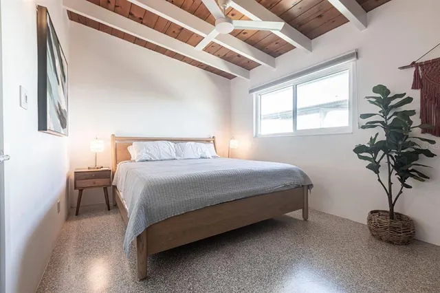a bedroom with a bed potted plant and a window