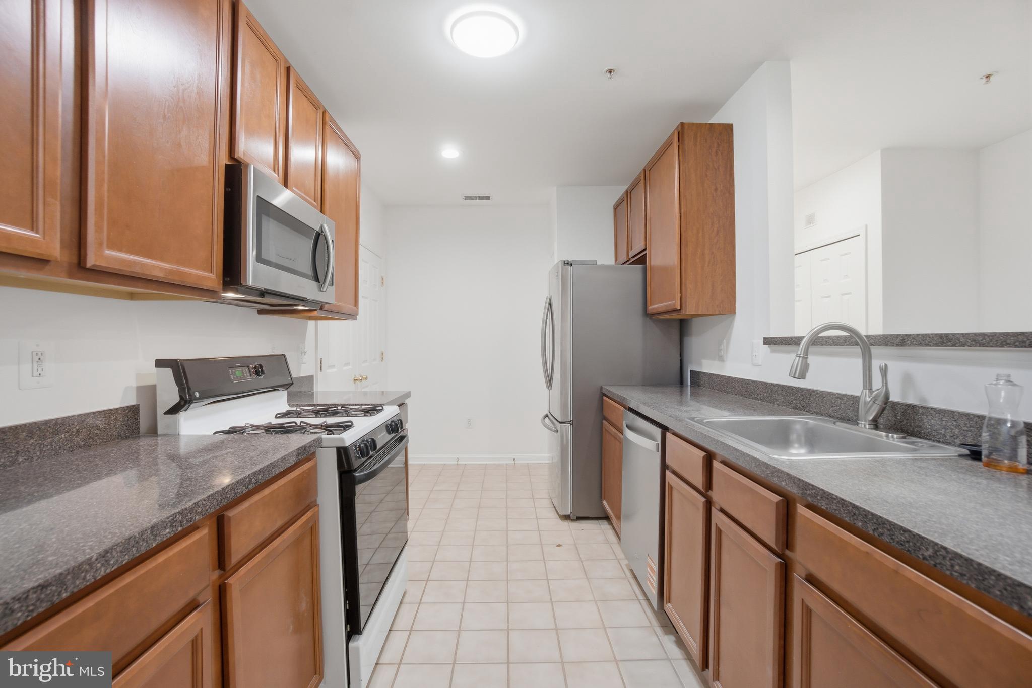 34 Hawk Rise Lane, Unit 103 Owings Mills, MD 21117 - Photo 11 of 29 a kitchen with stainless steel appliances granite countertop a sink stove and refrigerator
