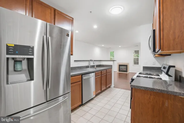 a kitchen with stainless steel appliances granite countertop a refrigerator stove and sink