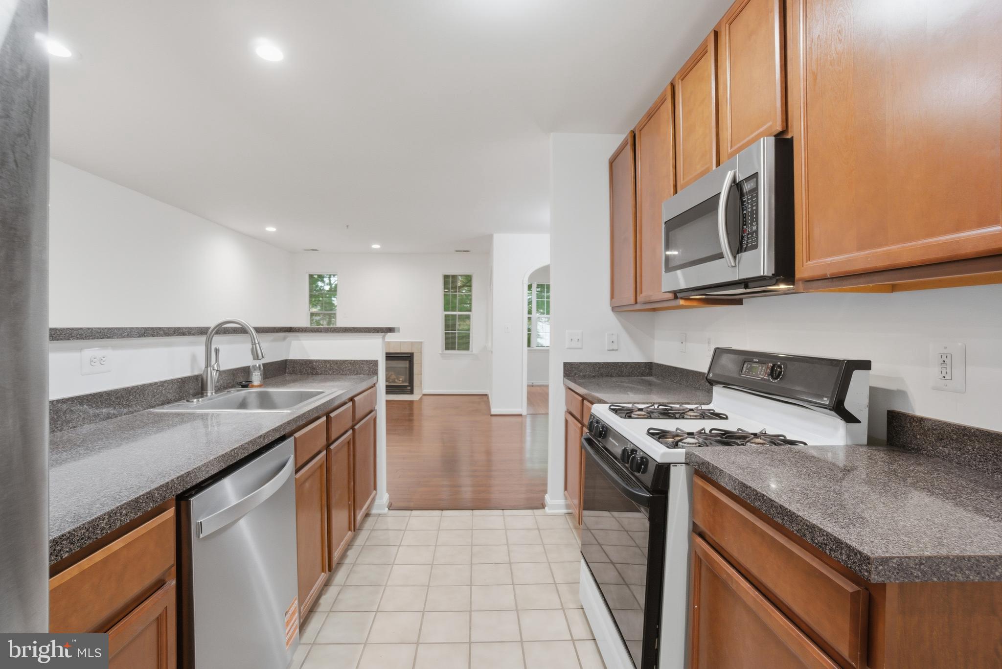 34 Hawk Rise Lane, Unit 103 Owings Mills, MD 21117 - Photo 13 of 29 a kitchen with stainless steel appliances granite countertop a stove a sink and a microwave