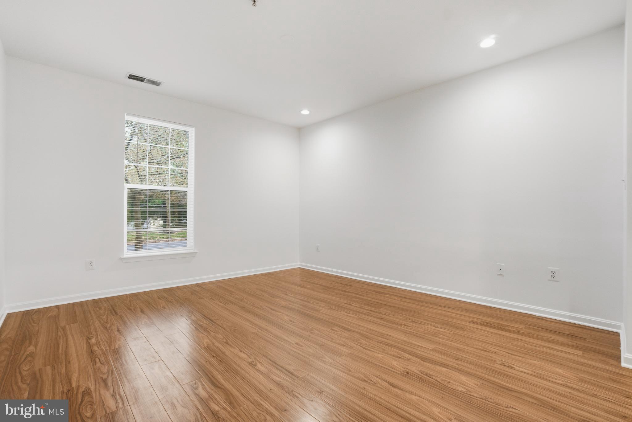 34 Hawk Rise Lane, Unit 103 Owings Mills, MD 21117 - Photo 15 of 29 a view of an empty room with wooden floor and a window