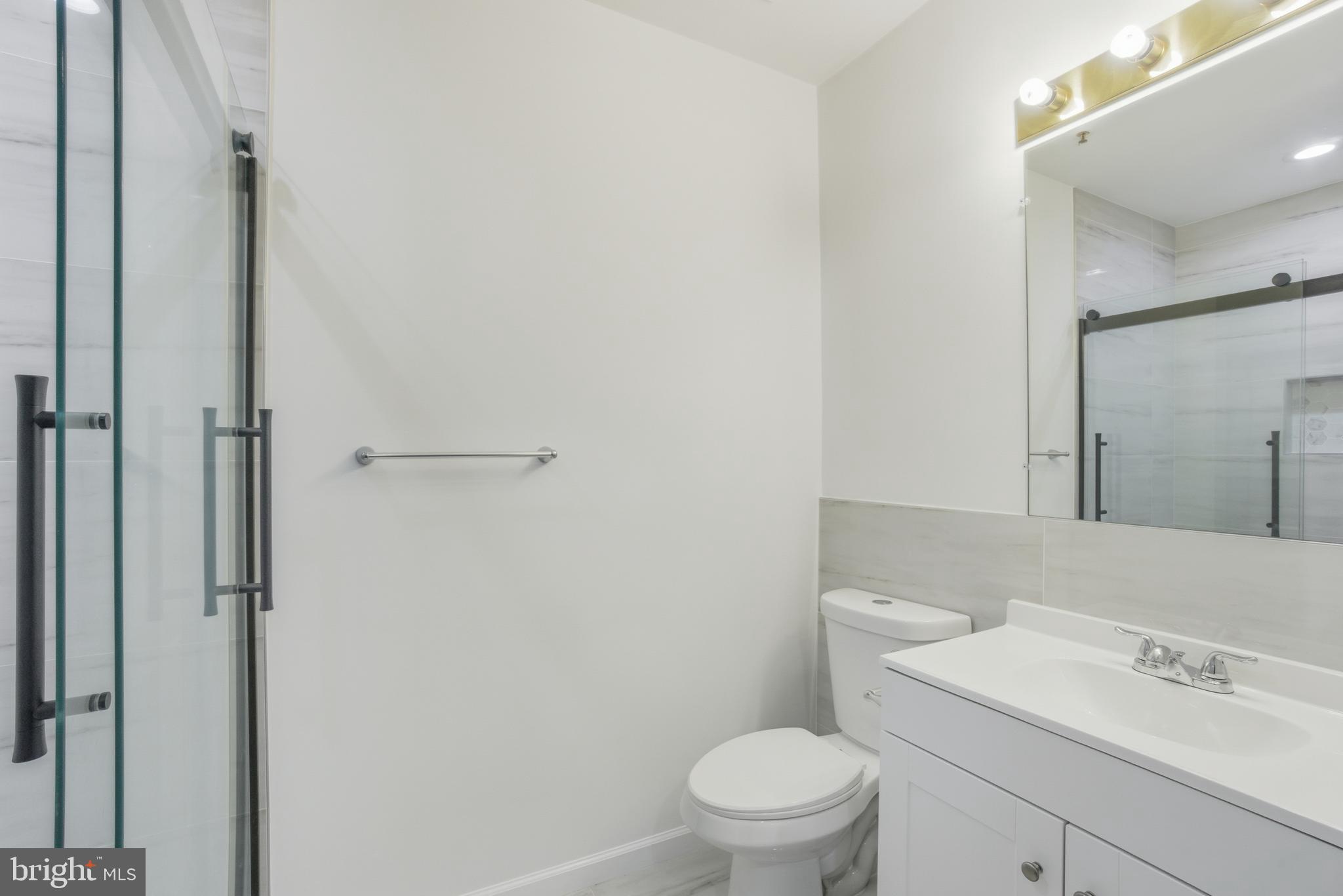 34 Hawk Rise Lane, Unit 103 Owings Mills, MD 21117 - Photo 19 of 29 a bathroom with a sink a toilet and a mirror