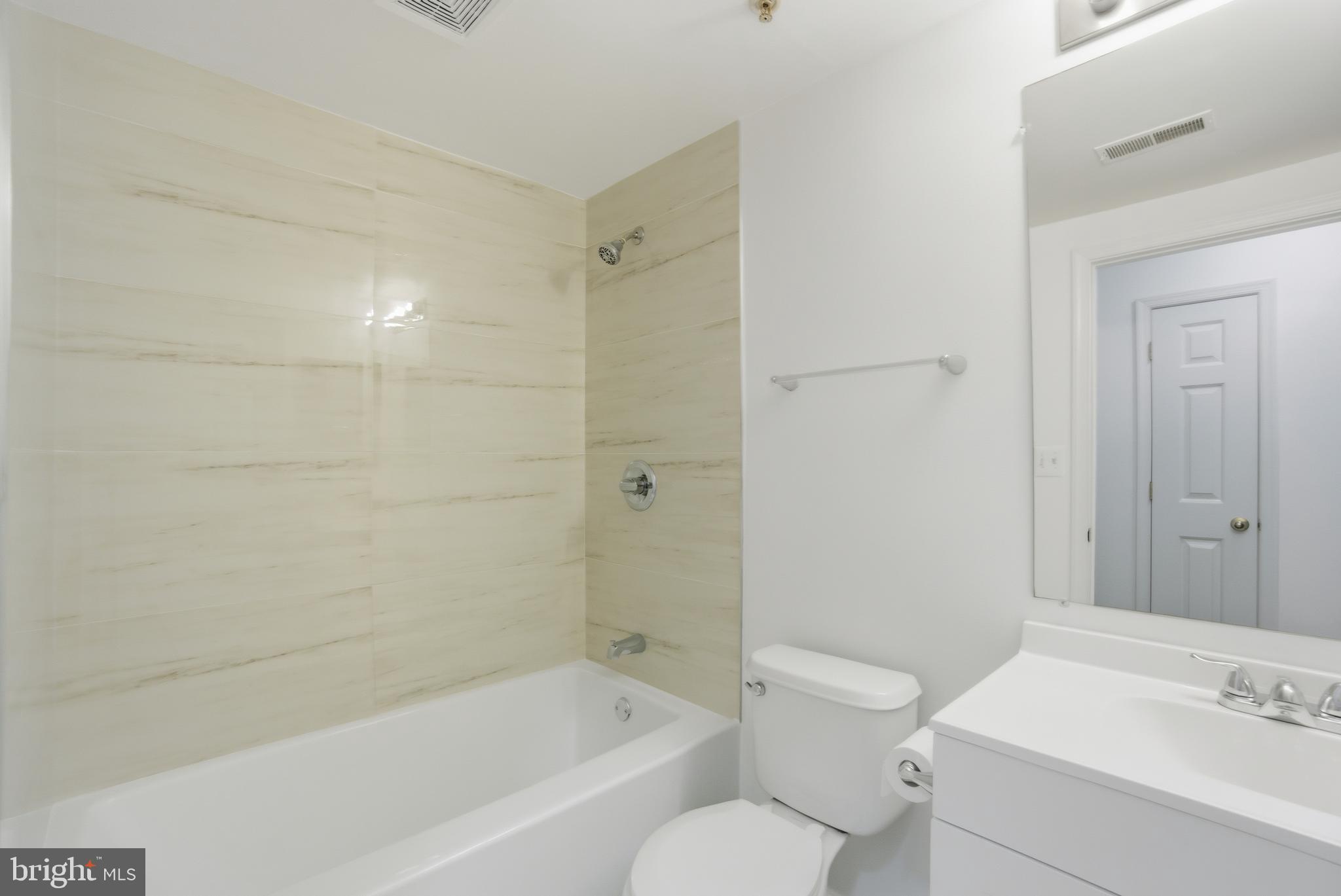 34 Hawk Rise Lane, Unit 103 Owings Mills, MD 21117 - Photo 22 of 29 a bathroom with a bathtub shower sink vanity and toilet