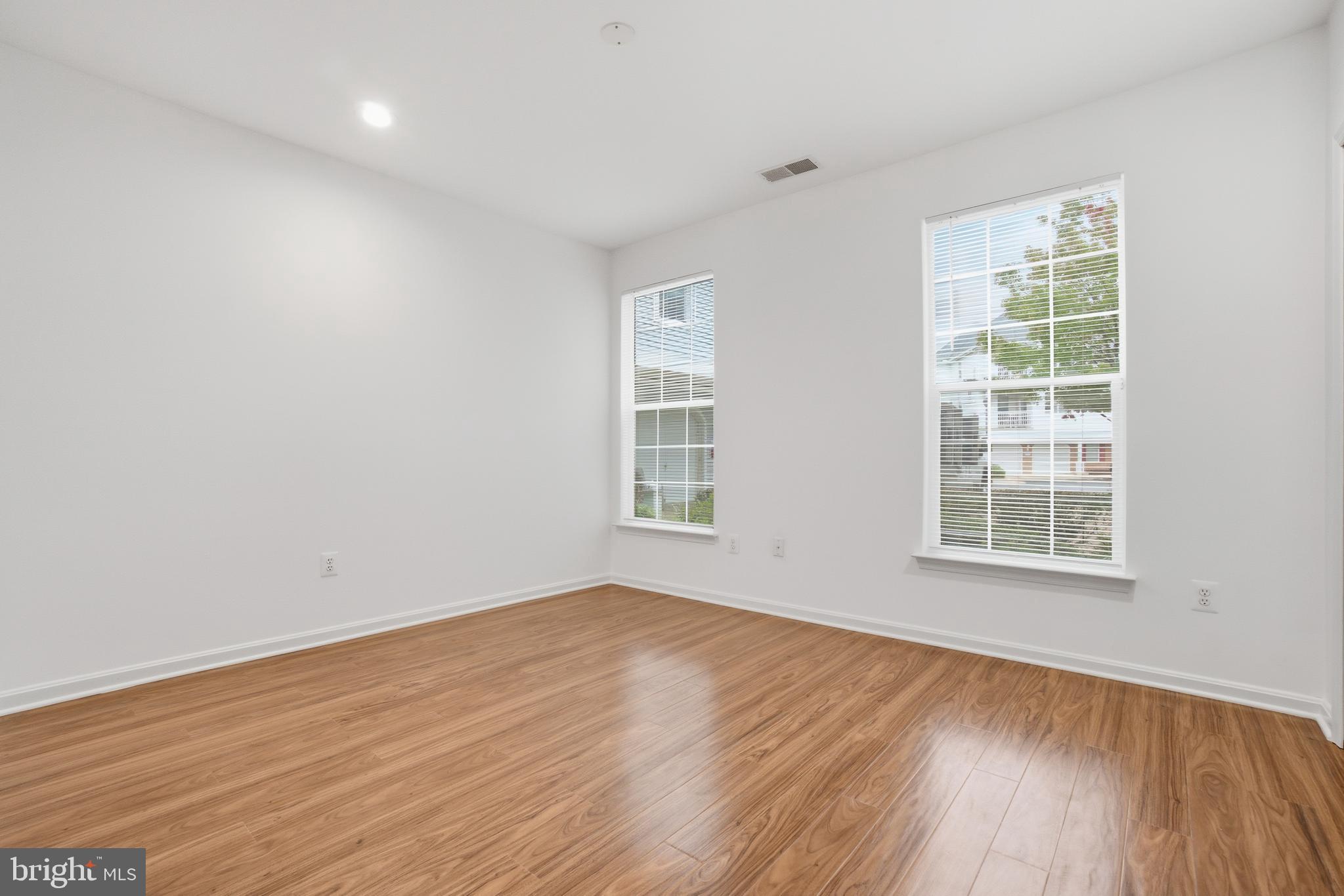 34 Hawk Rise Lane, Unit 103 Owings Mills, MD 21117 - Photo 23 of 29 an empty room with wooden floor and windows
