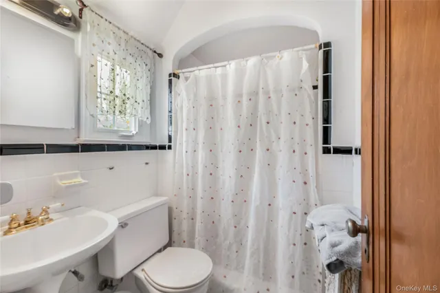 a bathroom with a sink a toilet and shower curtain