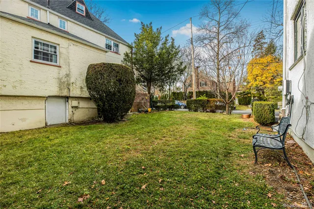 a view of a chair and table in backyard of the house