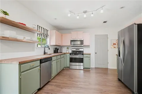 a kitchen with stainless steel appliances a refrigerator sink and cabinets