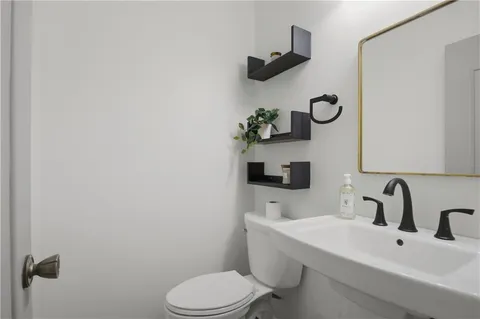 a bathroom with a sink mirror and toilet