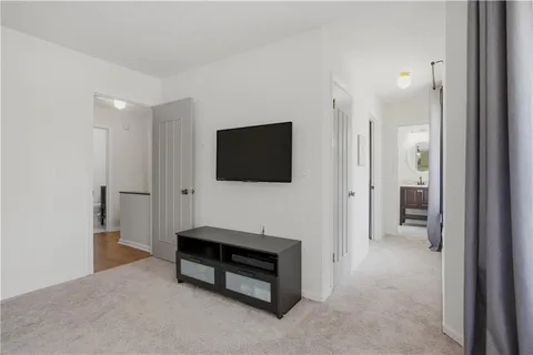 a spacious bedroom with a bed and a flat screen tv
