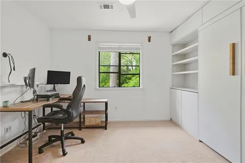 a view of a workspace with furniture and a window