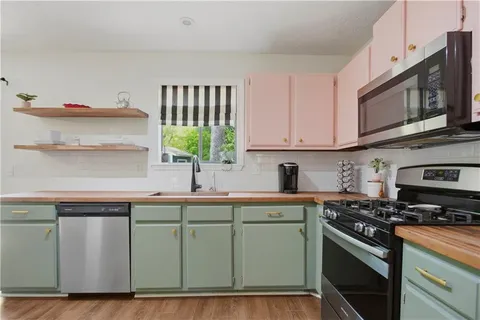 a kitchen with stainless steel appliances granite countertop a sink a stove and cabinets