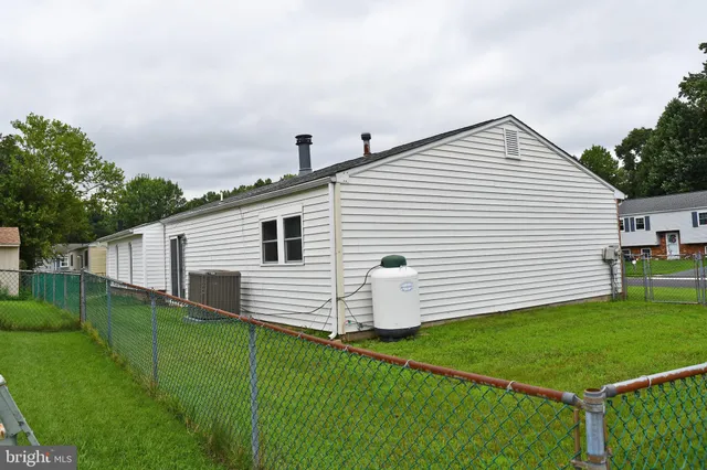 a view of a white house in the back yard