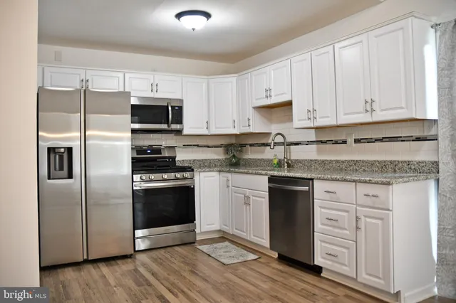 a kitchen with cabinets stainless steel appliances and a counter space