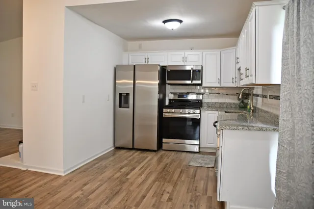 a kitchen with stainless steel appliances granite countertop a refrigerator stove and sink