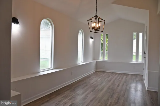 a view of a room with wooden floor and windows