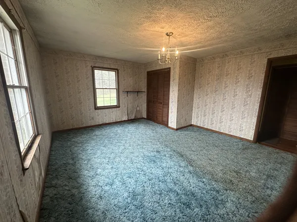 an empty room with windows and closet