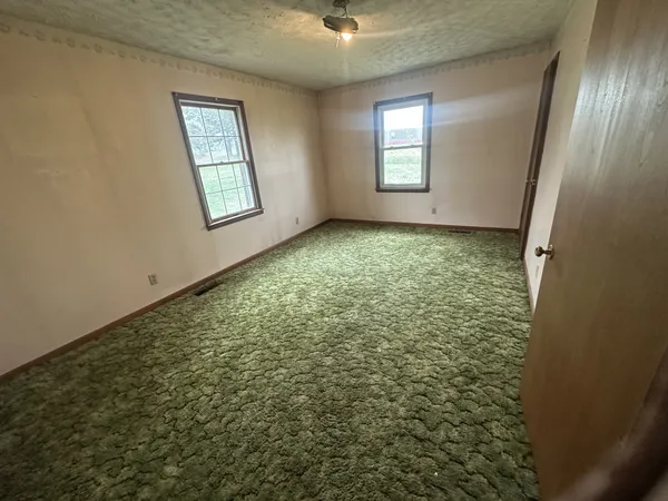 an empty room with windows and closet