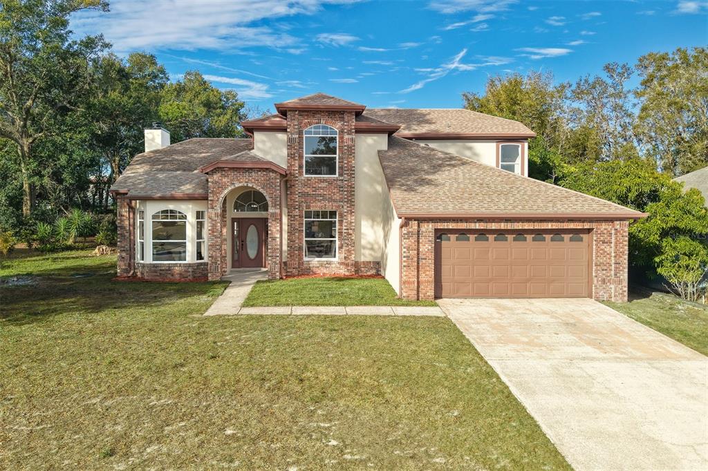 5010 Labrador Lane Orlando, FL 32818 - Photo 1 of 1 a front view of a house with a yard and garage