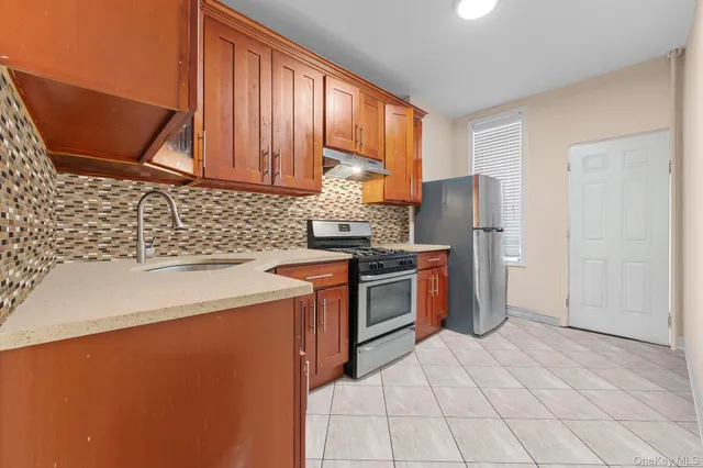a kitchen with stainless steel appliances granite countertop a refrigerator a sink a stove top oven and a dishwasher
