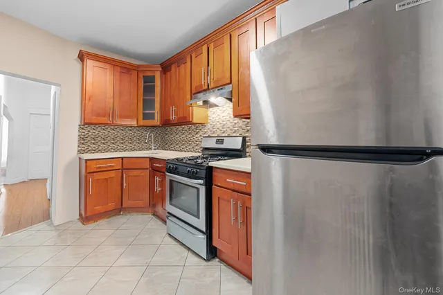 a kitchen with stainless steel appliances granite countertop a refrigerator and a stove top oven