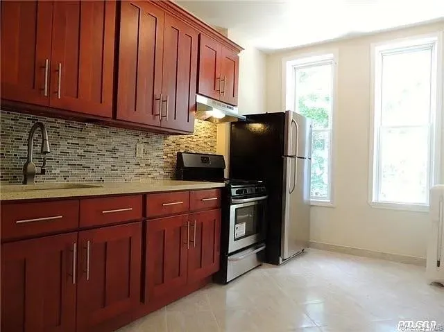 a kitchen with stainless steel appliances granite countertop a refrigerator stove and sink