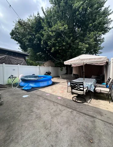a view of patio with chairs and table under an umbrella