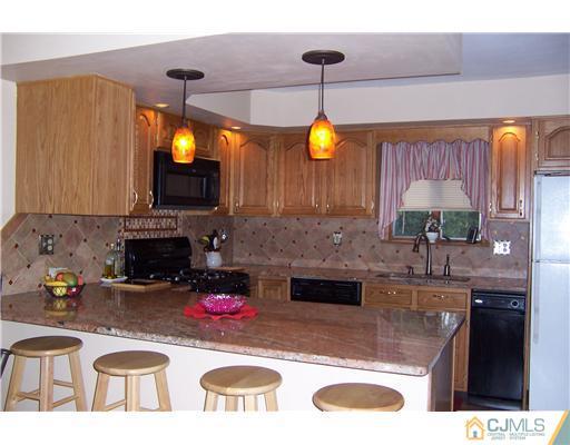 528 Chain O' Hills Road Colonia, NJ 07067 - Photo 3 of 25 a kitchen with kitchen island granite countertop a sink a stove and a wooden floors