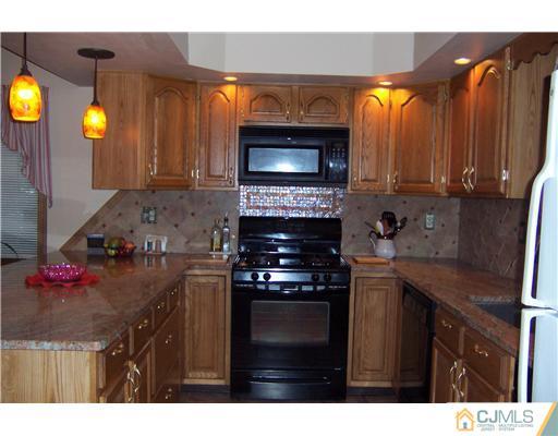 528 Chain O' Hills Road Colonia, NJ 07067 - Photo 4 of 25 a kitchen with stainless steel appliances granite countertop a stove a sink and a microwave