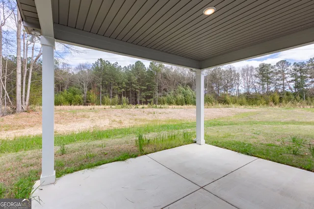 a view of a backyard with table and chairs under an umbrella