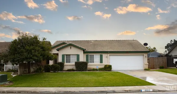a front view of a house with a garden and yard