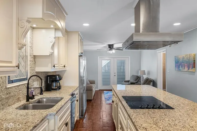a kitchen with stainless steel appliances granite countertop a sink stove and refrigerator